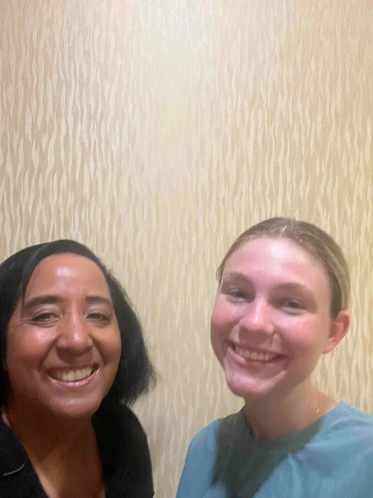 Nina smiling next to a client after a home session