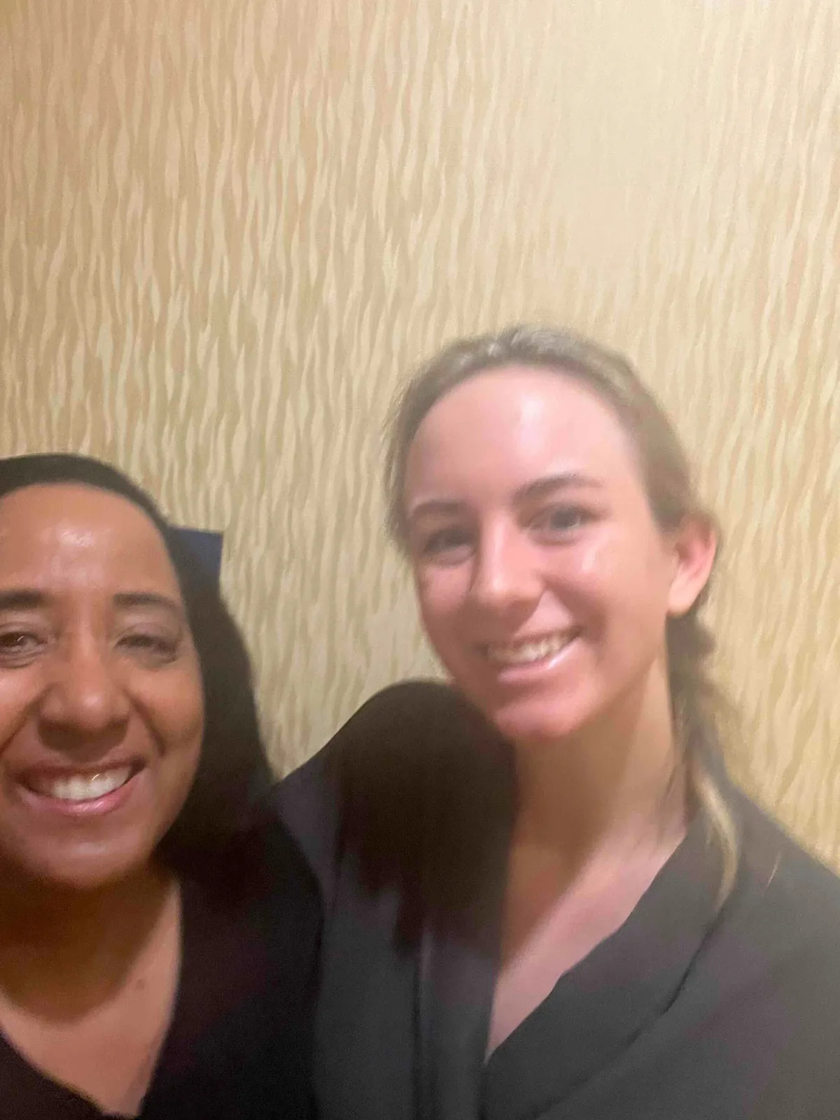 Nina and a returning client laughing together after their appointment