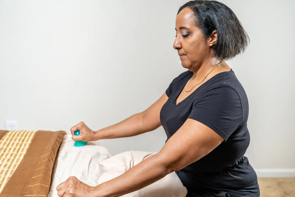 Nina holding a cupping cup beside the table, ready to begin a treatment