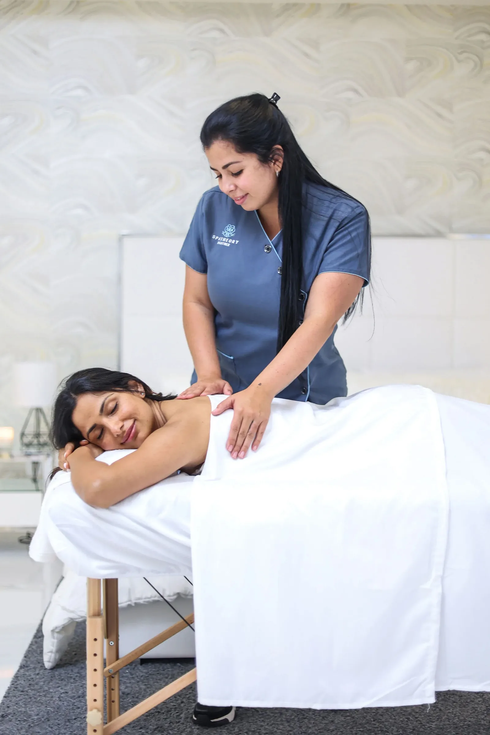Client relaxing face down on a draped massage table during a full-body session